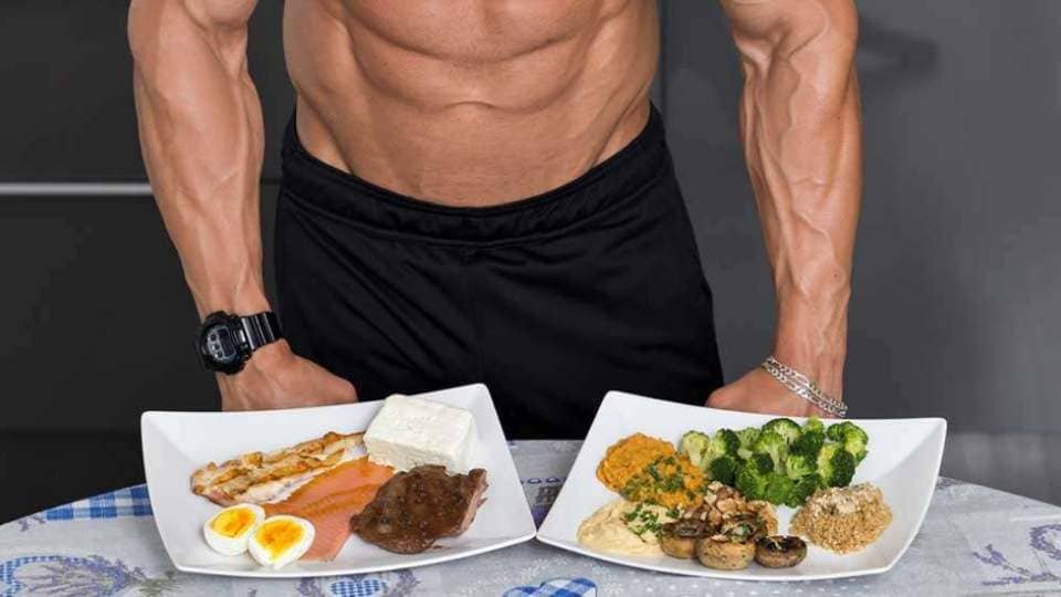 man standing by two plates of food one with carbs one without